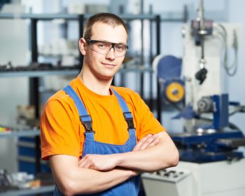 Mężczyzna w pomarańczowej koszulce i okularach w pracowni